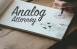doodling flower and mushroom on a paper pad with Analog Attorney logo