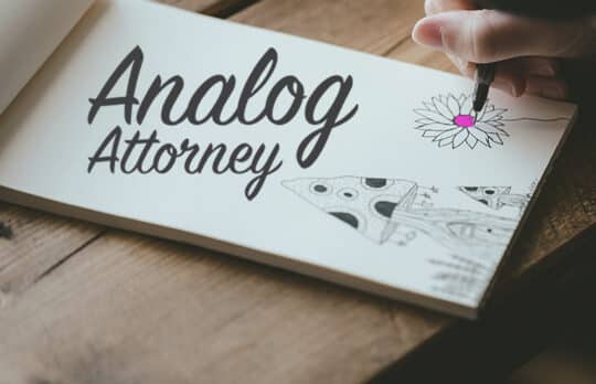 doodling flower and mushroom on a paper pad with Analog Attorney logo