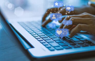 lawyer typing on a keyboard with icons representing social media for law firms