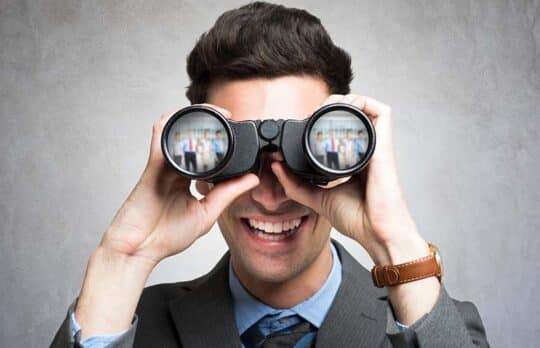 businessman looking through binoculars to ressearch small business referrals