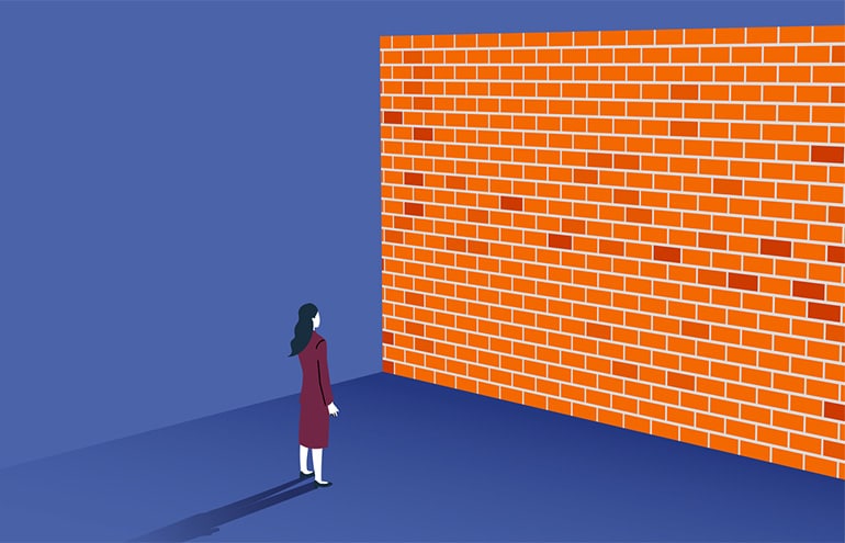 lawyer standing in front of a large brick wall representing emotional walls