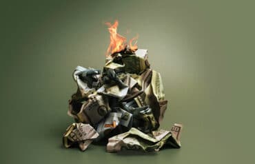 Burning pile of cash representing the hidden costs of bad hires in small law firms