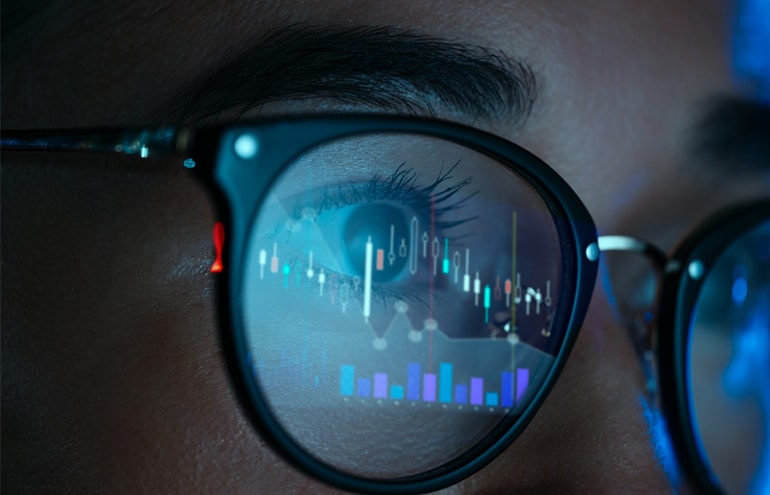 Close-up of glasses reflecting law firm financial reporting charts and data.