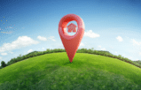 Red location pin on a green hill representing growth in niche land markets.
