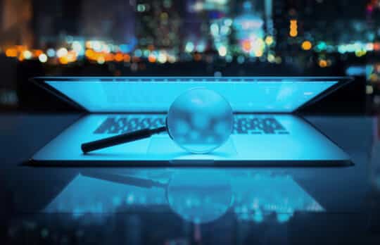 Magnifying glass over a glowing laptop, symbolizing the analysis of AI metrics for law firms.