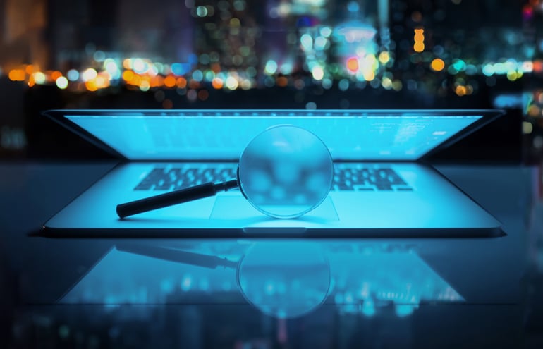 Magnifying glass over a glowing laptop, symbolizing the analysis of AI metrics for law firms.