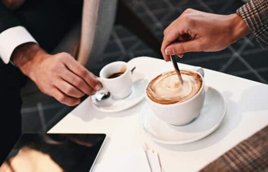 Two lawyers discuss in-person legal practice over coffee to build rapport and vet clients.