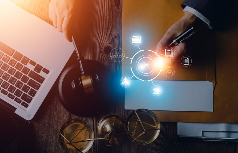 Overhead view of a gavel, scales of justice, and a hand signing papers representing digital marketing for law firms.