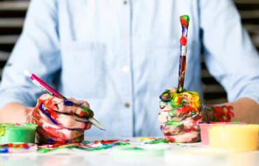 businessperson holding a pencil and paintbrush to illustrate why lawyers need a creative rest