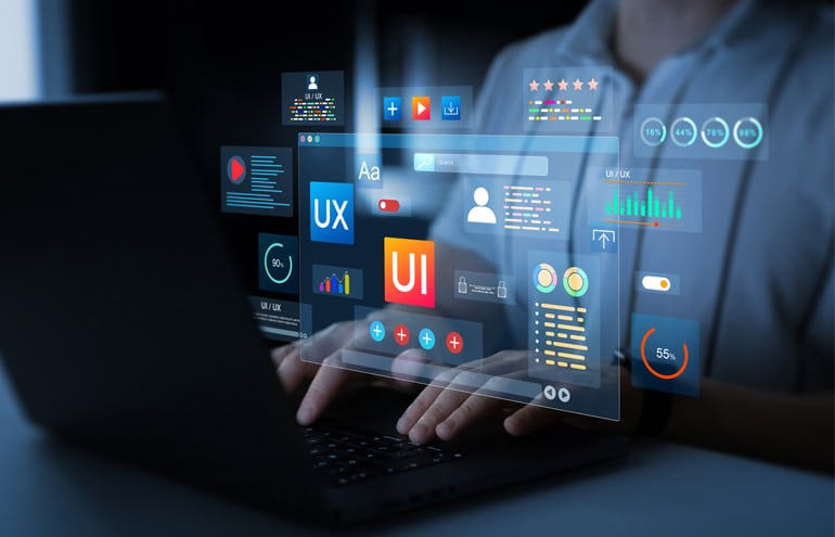 A designer typing on a laptop with floating UI and UX graphics representing an optimized law firm website layout.