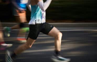 Two men running side-by-side outdoors, illustrating how physical endurance and marathon training improve trial attorney skills.