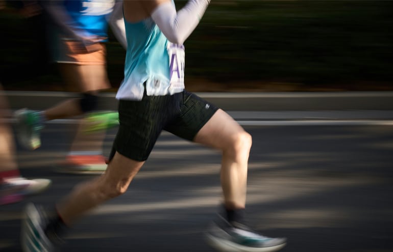 Two men running side-by-side outdoors, illustrating how physical endurance and marathon training improve trial attorney skills.
